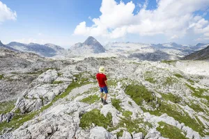 Hiker looks into the distance, landscape of washed out karst stone rocks