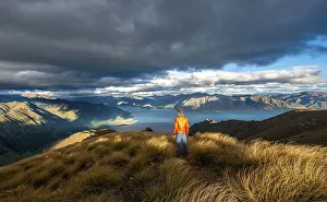 Hiker looks into the distance, view of Lake Hawea in the evening light