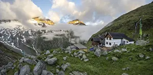 Hiker looks at mountain peaks with last sunlight