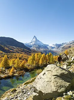 Hiker Man on Top of Boulder Looking at Matterhorn Mountain