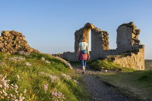 A hiker on a path in the ruins of Botallack Mine