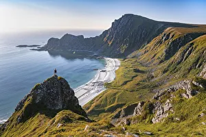 Hiker on rocks, cliffs, beach and sea