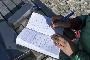 Hiker signs the summit book, summit of the Mitterhorn