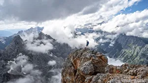 Hiker standing on a rock, at the summit of the Partenkirchner Dreitorspitze