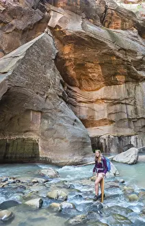 Hiker walking through river, Zion Narrows