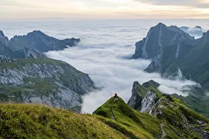 Two hikers enjoying the view over the Saentis mountains into the valley of Meglisalp at sunrise