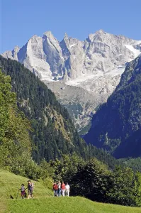 Hikers on the hiking trail Via Bregaglia walking towards the Bondasca group with Sciora