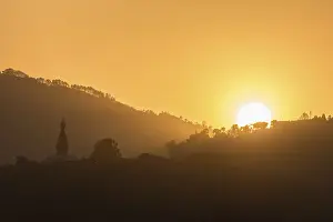 Hills with trees and buddhist temple at sunset