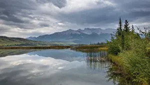 Hilly, mountainous landscape, trees reflected in a lake