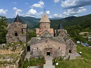 Historic Armenian monastery against a mountain backdrop and blue sky