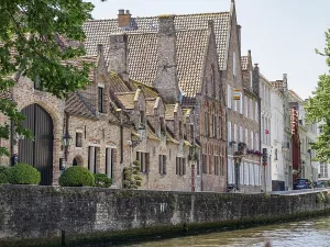 Historic brick houses and well-kept bushes along a canal in clear summer weather
