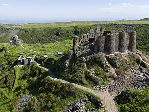 Historic castle ruins on green hills surrounded by nature