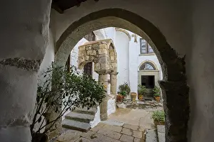 Historic courtyard of a monastery with stone arches and Mediterranean architecture