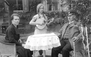 Historic photo, parents with daughter who is playing music