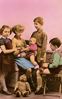 Historic photograph, two boys and two girls with a teddy and a doll