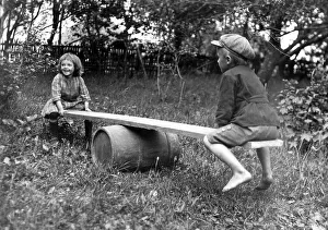 Historic photograph, two children on a seesaw in the garden