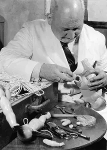 Historic photograph, man repairing dolls