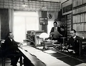Historic photograph, three men and an apprentice working in an office