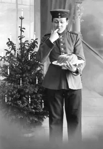Historic photograph, person in uniform in front of a Christmas tree