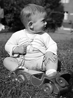 Historic photograph, small boy playing with a wooden car