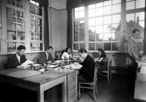 Historic photograph, two women and four men working in an office