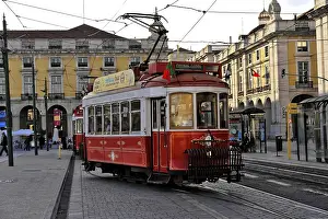 Framed Print : A historic red tram runs through the city center past impressive old architecture Framed Print : A historic red tram runs through the city center past impressive old architecture