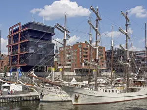 Framed Print : Historic sailing ships in the harbor in front of modern city architecture under clear skies