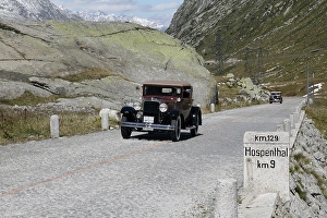 Historic section of cobblestone pavement on the old Gotthard pass route with milestone to Hospental and Oldtimer
