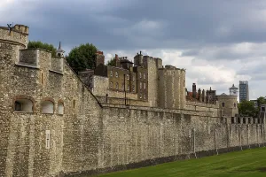 Historic stone walls of a fortification under a cloudy sky at The Tower of London