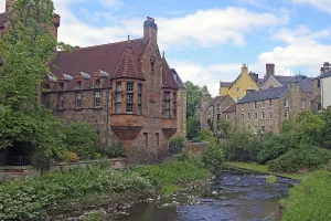 Historic waterfront buildings with green trees and clear skies