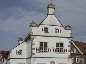 Historic, white and red half-timbered house with ornate windows