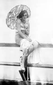 Holiday, woman with parasol and swimsuit at the jetty