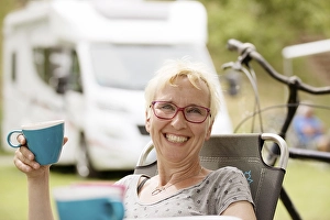 Holidaymaker, camper in front of motorhome with cup in hand