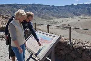 Holidaymakers, tourists reading information board at the foot of the Teide
