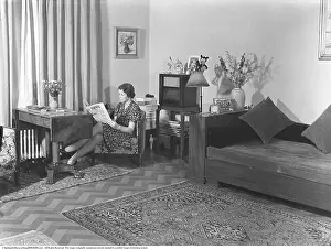 Home life in 1941. A woman sits reading the daily newspaper Falbygdens Tidning in a modestly furnished room