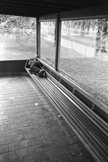 Homeless in the 1950s. A man is pictured sleeping on the bench at a bus stop