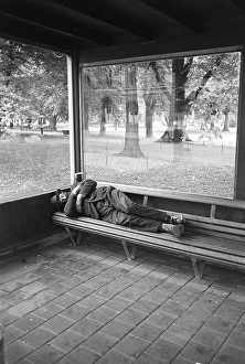 Homeless in the 1950s. A man is pictured sleeping on the bench at a bus stop