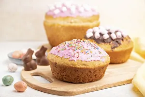 Homemade glazed and decorated easter pies with chocolate eggs and rabbits on a white concrete background