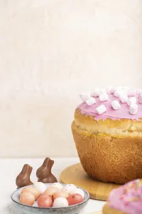Homemade glazed and decorated easter pies with chocolate eggs and rabbits on a white concrete background