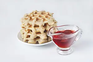 Homemade waffles with strawberry jam on a white background