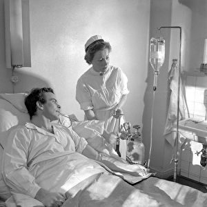Hospital in the 1950s. A nurse adjusts the oxygen that is given to the patient who also is seen recieving intravenous therapy. Sweden 1952 Conard ref 1931