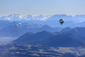 Hot air balloon flying in front of a mountain landscape