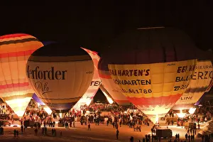 Hot air balloons glowing against a night sky