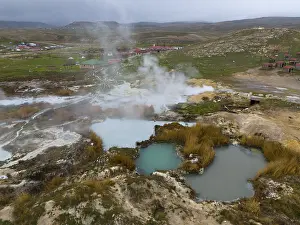 Framed Print : Hot springs with rising steam in a wide landscape with mountains in the background