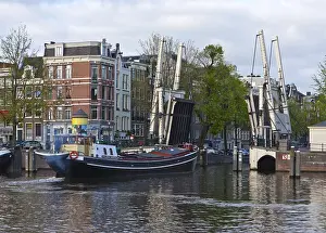 House boat passing the raised Walter Suskind Brug drawbridge