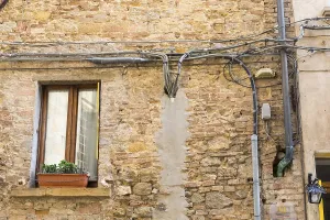 House wall with exposed power cables