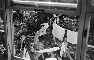 Two housewives hanging up laundry