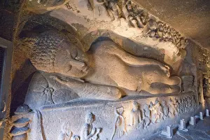 Huge figure of reclining buddha laying back in preparation for nirvana at ajanta caves