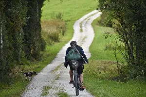Hunter on a bicycle with rucksack and rifle