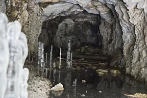 Ice stalagmites and frozen formations in a dark quarry cave in Fengersfors